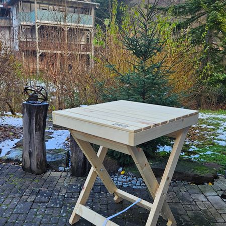 Ein Stehtisch aus Paletten steht im Garten