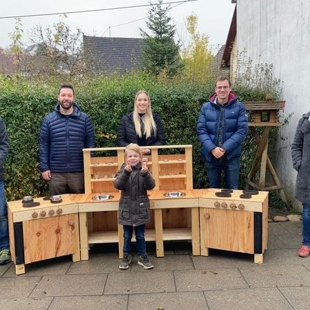 Mehrere Personen stehen um Matschküche herum